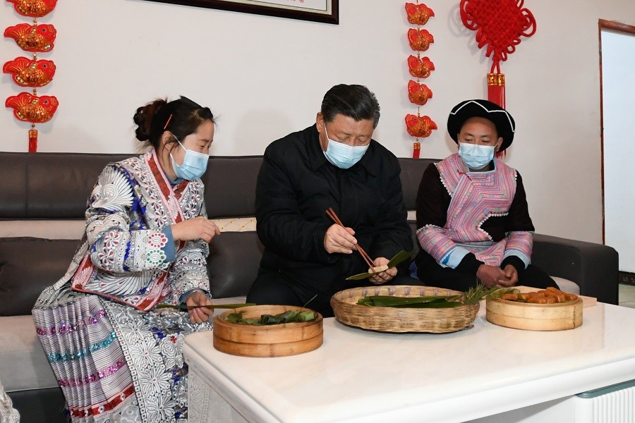 2021年2月3日下午，習(xí)近平在貴州畢節(jié)市黔西縣新仁苗族鄉(xiāng)化屋村苗族村民趙玉學(xué)家，同一家人邊聊家常邊制作當(dāng)?shù)貍鹘y(tǒng)節(jié)日食品黃粑。新華社記者 李學(xué)仁 攝
